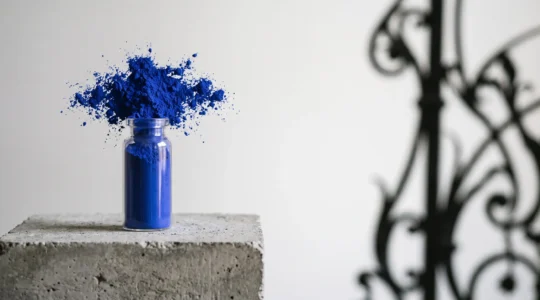 Composition symbolique évoquant le pigment bleu outremer et la quête d'infini d'Yves Klein, avec une touche architecturale belge en arrière-plan
