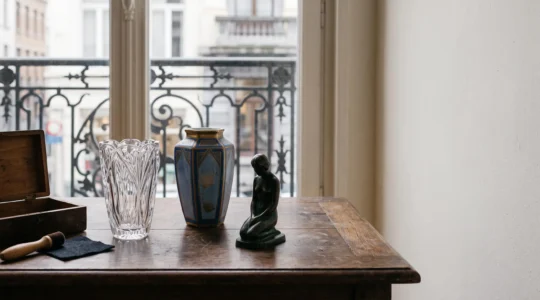 Nature morte élégante de plusieurs objets d'art de collection posés sur une table en bois dans une lumière naturelle douce